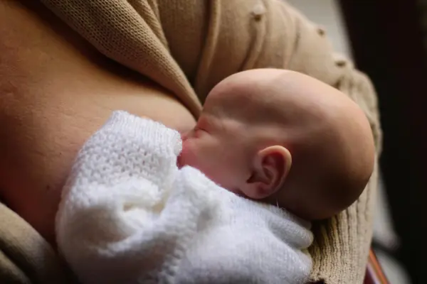 A close-up of a baby breastfeeding, representing the supportive clinical management of acute mastitis and breastfeeding preservation provided by Monty Pelvic Physio in Eltham and Montmorency.