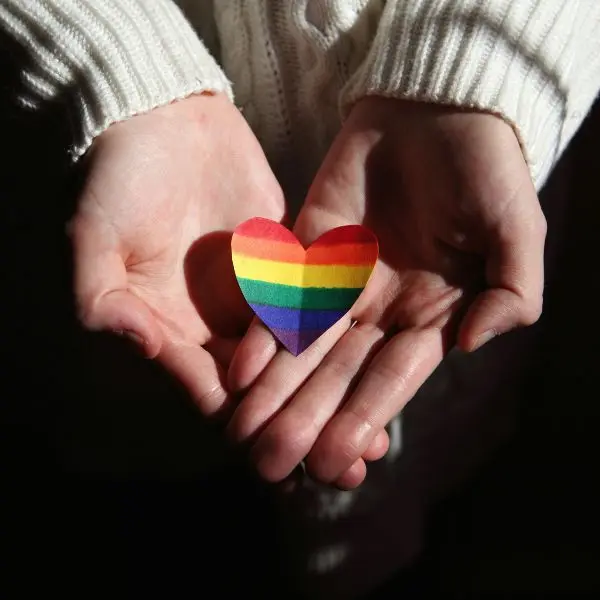 inclusive-clinical-environment-pelvic-wellness-nillumbik Close-up of hands on a progress pride flag fabric representing the neurodiverse and LGBTQ+ friendly clinical environment and the respectful approach to pelvic health assessments provided at Monty Pelvic Physio in Northeast Melbourne.